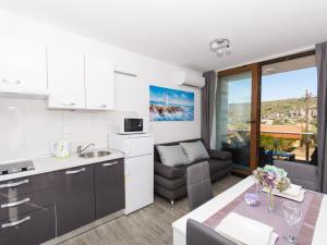 a kitchen and living room with a couch and a table at Villa LA-Comfort One Bedroom Apartment with Sea View Terrace 1 in Veliki Drvenik