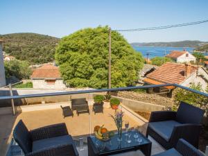 a balcony with chairs and a table with a view at Villa LA-Comfort One Bedroom Apartment with Sea View Terrace 1 in Veliki Drvenik