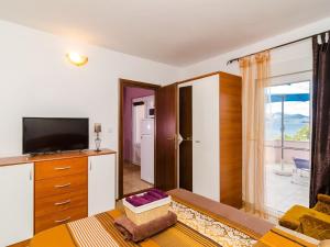 a living room with a tv and a large window at Apartment Bay Of Dreams - Two-Bedroom Apartment with Terrace and Sea View in Janjina