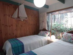 ein Schlafzimmer mit zwei Betten und einem Fenster in der Unterkunft Alba the Scots Cottage walk every where in Maleny