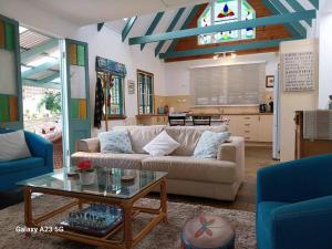 ein Wohnzimmer mit Sofa und Tisch in der Unterkunft Alba the Scots Cottage walk every where in Maleny
