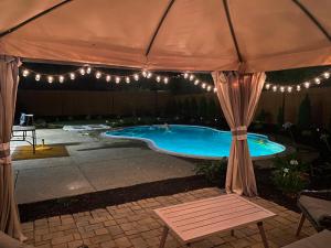 a tent over a swimming pool with lights at NEW cozy beautiful house with pool and hot tub in Fair Oaks
