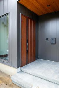 una puerta de madera en el lateral de un edificio en EKVOLI MARINA VILLA, Isumi Garden, en Chōjamachi 69 fotos más