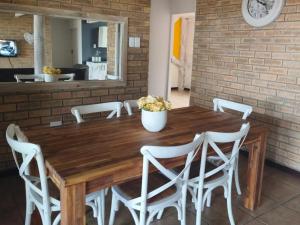 a wooden table with white chairs around it at Boitumelo Bluewater Apartments in Port Elizabeth