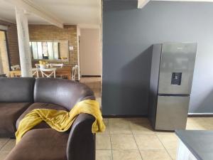 a living room with a couch and a refrigerator at Boitumelo Bluewater Apartments in Port Elizabeth +54 photos