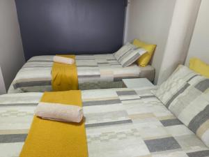 two beds in a small room with towels on them at Boitumelo Bluewater Apartments in Port Elizabeth