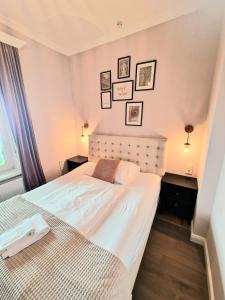 una camera con un letto bianco e immagini appese al muro di Casa Lucia a Knittelfeld