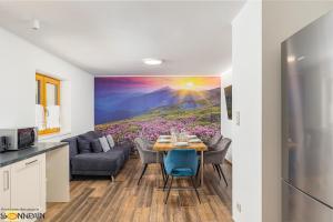 a kitchen and living room with a painting of flowers at Sonnrain GmbH Apartment Sonnberg 77 Leogang in Leogang