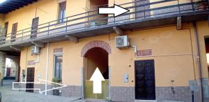 a building with a door with an arrow pointing up at Corte Malpensa in Somma Lombardo