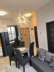 a living room with a table and chairs and a chandelier at Komfortowa Miła z garażem i tarasem, klimatyzacja, self check in in Rzeszów