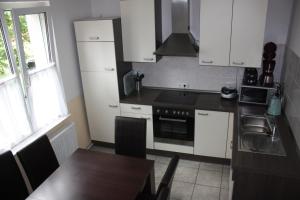 a kitchen with white cabinets and a wooden table at Schwalbe in Saal