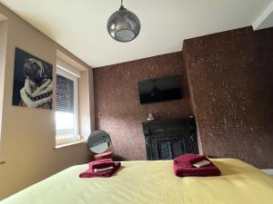 a bedroom with a bed with two red towels on it at Aux Deux Tours in Leval