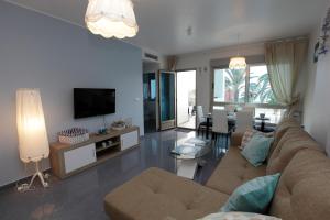 a living room with a couch and a television at Gran Lugar -Mar Azul in La Manga del Mar Menor