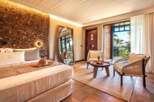 una camera da letto con un letto grande e una grande finestra di Palm Hotel & Spa a Petite-Île