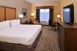 ein Hotelzimmer mit einem Bett und einem Flachbild-TV in der Unterkunft Holiday Inn Express & Suites Page - Lake Powell Area, an IHG Hotel in Page