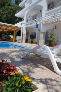 a white bench in front of a house at Bonaca in Sutomore