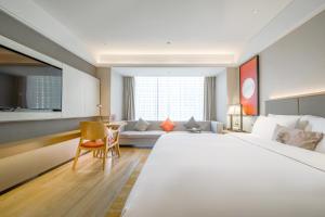 南宁Nanning Vientiane City Convention and Exhibition Center Yicheng Hotel的配有一张大床和一张沙发的酒店房间