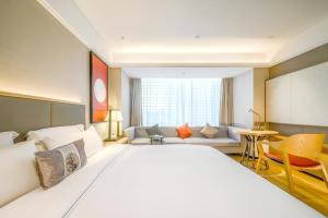 南宁Nanning Vientiane City Convention and Exhibition Center Yicheng Hotel的配有一张大床和一张沙发的酒店房间