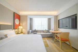 南宁Nanning Vientiane City Convention and Exhibition Center Yicheng Hotel的一间带大床的卧室和一间客厅