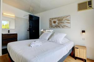 una camera con letto bianco e lavandino di Villa Vénus - classée 4 étoiles - Piscine et vue mer - Saint-Gilles les Bains a L'Ermitage-Les-Bains Altre 29 foto