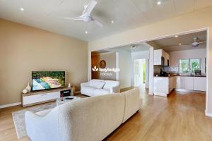un soggiorno con un divano e una TV di Villa Vénus - classée 4 étoiles - Piscine et vue mer - Saint-Gilles les Bains a L'Ermitage-Les-Bains