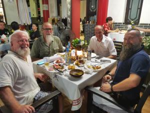 a group of men sitting around a table with food at Wenjun Courtyard Hotel ---5 mins walk from Tonghuimen metro station, near Tianfu square, close by culture park and Sichuan opera house, English speaking service, local tours in Chengdu