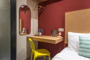 a bedroom with a yellow chair next to a bed at Mono Coliving Pakis, Surabaya in Wonokitri 2