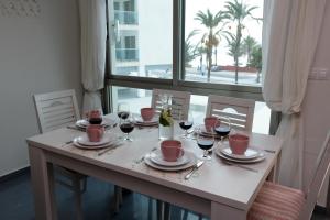 einen Tisch mit Gläsern Wein und einem Fenster in der Unterkunft Gran Lugar -Mar Azul in La Manga del Mar Menor