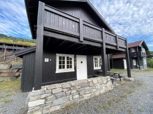a black and white building with a stone wall at Ruud Tun in Hafjell