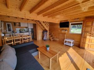 a living room with a couch and a table at Domki Gromadka in Wielen Zaobrzanski