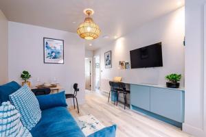 a living room with a blue couch and a kitchen at Elegant 2B Retreat City Centre with Secure Parking in Chester