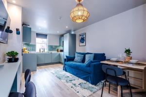 a living room with a blue couch and a table at Elegant 2B Retreat City Centre with Secure Parking in Chester