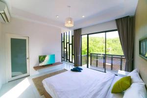 ein Schlafzimmer mit einem großen Bett und einem großen Fenster in der Unterkunft Enjoy Samui Residence in Bangrak Beach + 194 Fotos