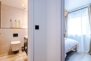 a bathroom with a bed and a toilet and a window at Elegant 2B Retreat City Centre with Secure Parking in Chester +23 photos