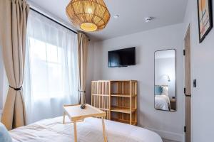 a bedroom with a bed with a table and a mirror at Elegant 2B Retreat City Centre with Secure Parking in Chester