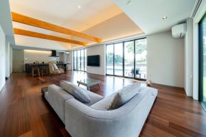 una sala de estar con un sofá y una mesa en EKVOLI MARINA VILLA, Isumi Garden, en Chōjamachi