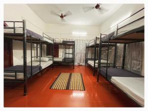 Habitación con 4 literas y alfombra. en Zion Backpackers Hostel, en Guwahati