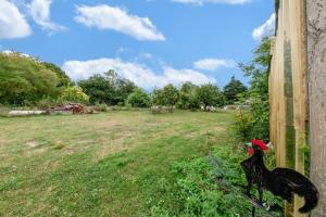 una recinzione con un pollo sul lato di un campo di Laureanna - Maison avec jardin de 1000 m2 a Descartes