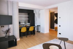 a living room with a table and yellow chairs at Electra Aparthotel in Rădăuţi