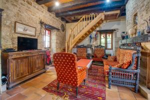 un soggiorno con sedie, televisione e scale di Cottage Périgourdin Grande Piscine a Saint-André-dʼAllas