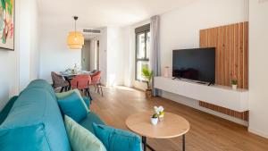 a living room with a blue couch and a table at Myflats Campello Beach in El Campello