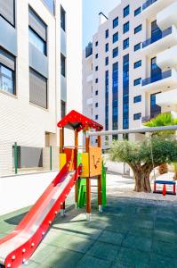 a playground with a slide in front of a building at Myflats Campello Beach in El Campello