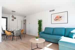 a living room with a blue couch and a table at Myflats Campello Beach in El Campello
