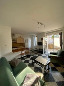 a living room with a green couch and a table at Maison accueillante à Orgnac-l'Aven avec piscine partagée in Orgnac-lʼAven