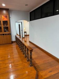 a staircase in a room with a white wall and a wooden floor at Penthouse ศรีราชา วิวทะเล ATHOME SRIRACHA in Ban Rai Kluai