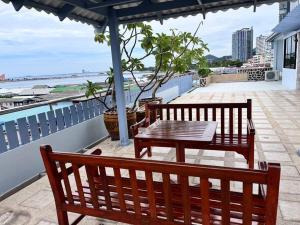 two benches and a table on a balcony at Penthouse ศรีราชา วิวทะเล ATHOME SRIRACHA in Ban Rai Kluai