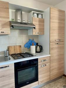 a kitchen with wooden cabinets and a stove top oven at Casina di Adele apartment in Volterra