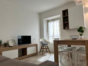 un soggiorno con un tavolo e una televisione di Fanzago Trilo Home a Clusone