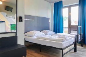 ein Schlafzimmer mit zwei Betten und blauen Vorhängen in der Unterkunft a&o Hamburg Reeperbahn in Hamburg + 19 Fotos