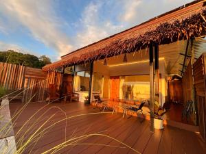 a deck of a house with a table and chairs at Gobgab Station room 2 in Ban Huai Khai